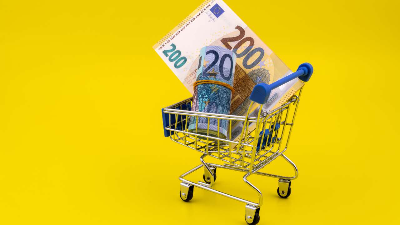 На желтом фоне тележка для покупок с евро банкнотами как символ ответственного заимствования